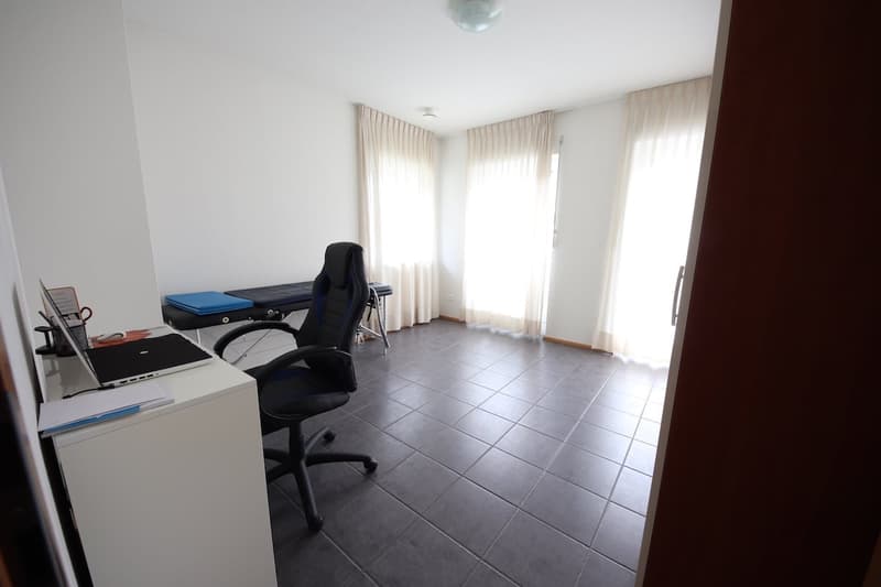 Empty room, desk with laptop, office chair, and exercise table
