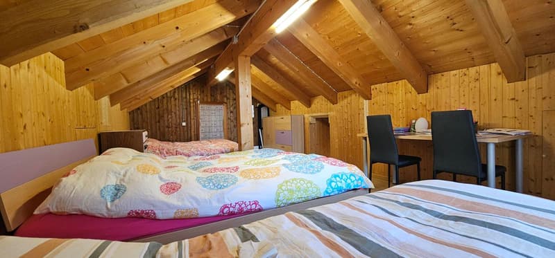wooden ceiling and wall, 3 beds, desk, office chair, cabinet, open door, bed cover, pillow
