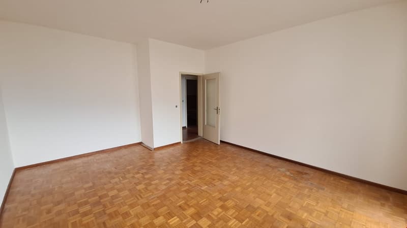 wooden floor, white walls, an open door leading to a hallway