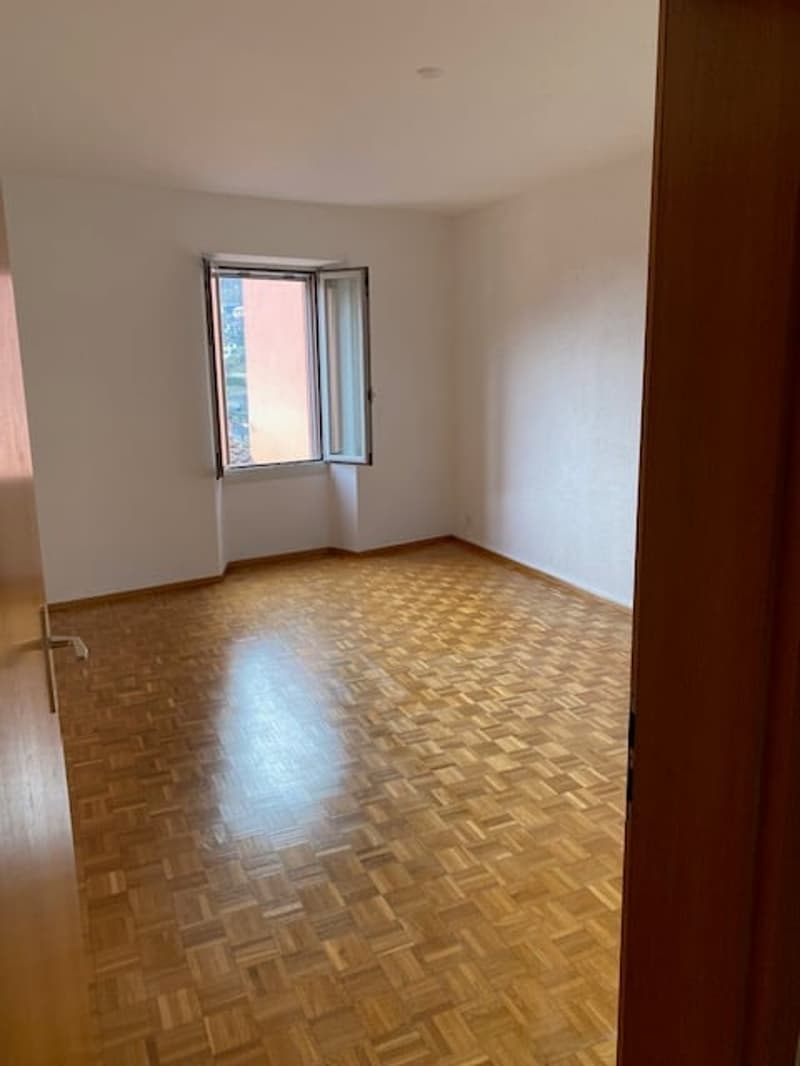 Empty room, wooden floor, balcony window, white walls