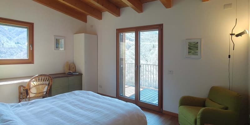bedroom with bed, chair, desk, cabinet, sliding glass door, balcony, wooden ceiling