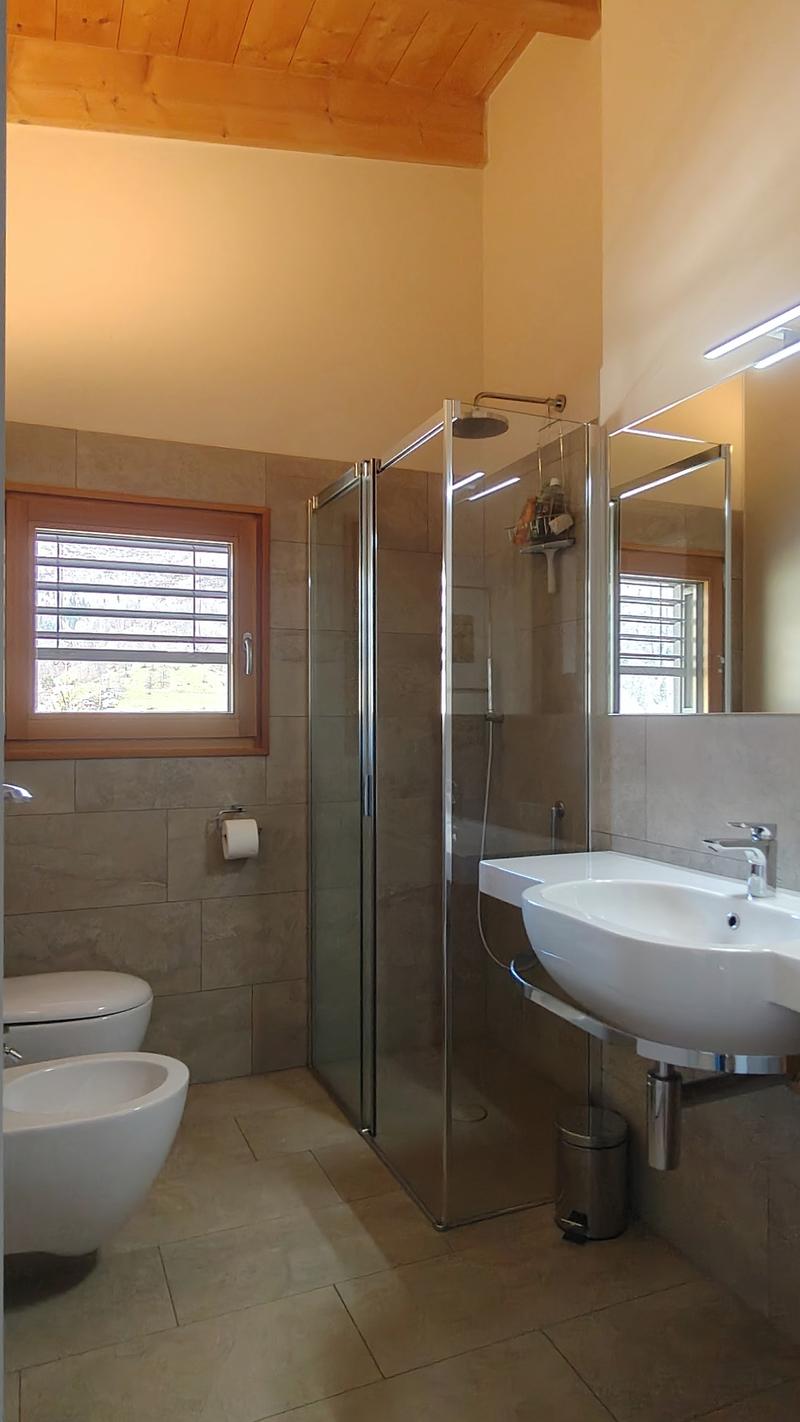 Bathroom with shower, sink, bidet, toilet, wooden ceiling, tiled floor, window with blinds