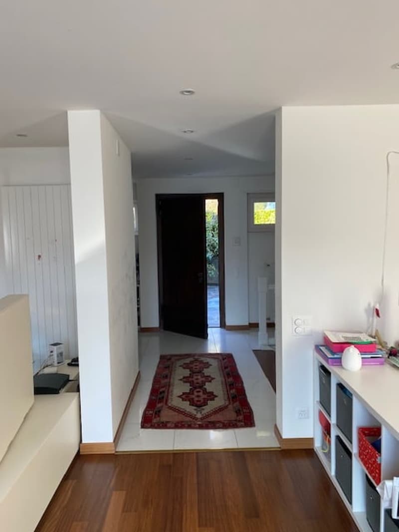 white walls, wooden floor, white tile, rug, open door, hallway