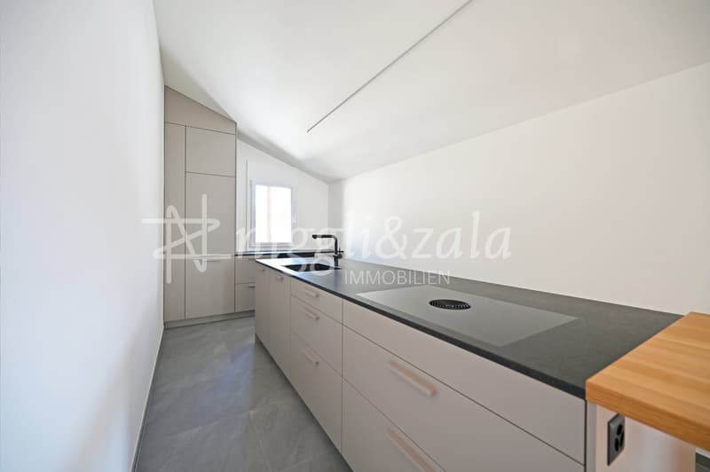 modern kitchen with white cabinets, gray countertops, wooden countertop, stainless steel sink, faucet, and a window