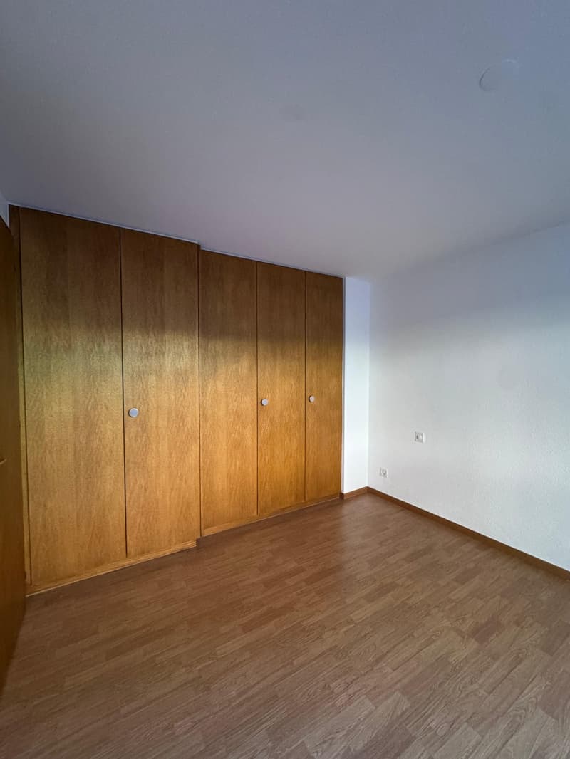 an empty room with wooden cabinets and a wooden floor