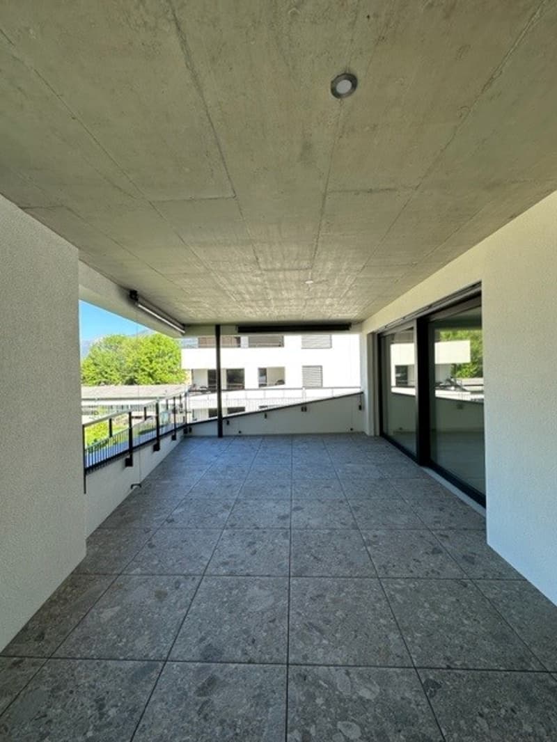 A raised ground floor balcony/terrace with tiled flooring and windows.