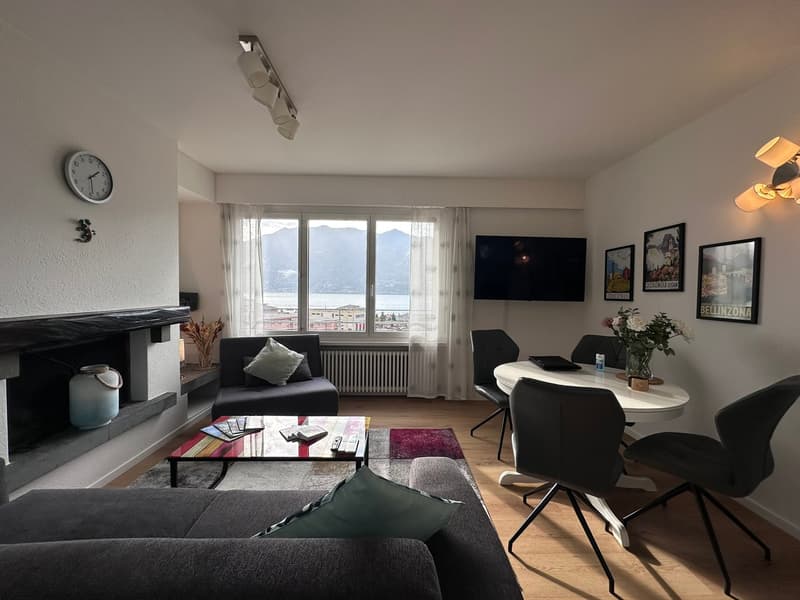 fireplace, mounted TV, dining table with 4 chairs, windows, couch, coffee table