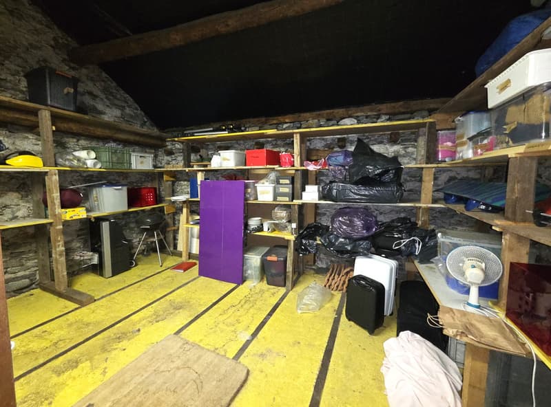 Storage room, wooden shelves, multiple storage boxes and bags, fan, small table
