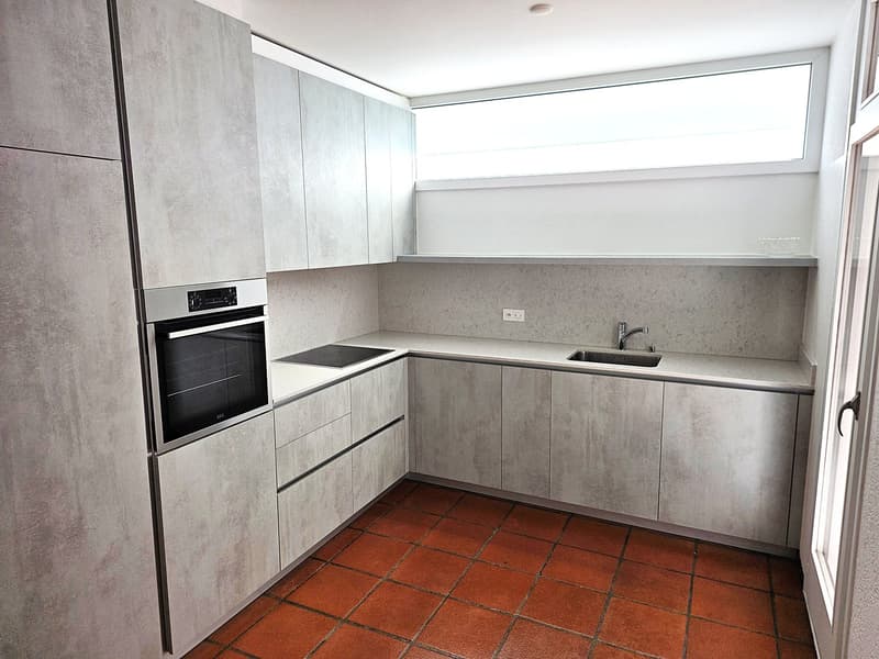 modern kitchen with gray cabinets, red tiles, built-in oven, sink, faucet, power outlet