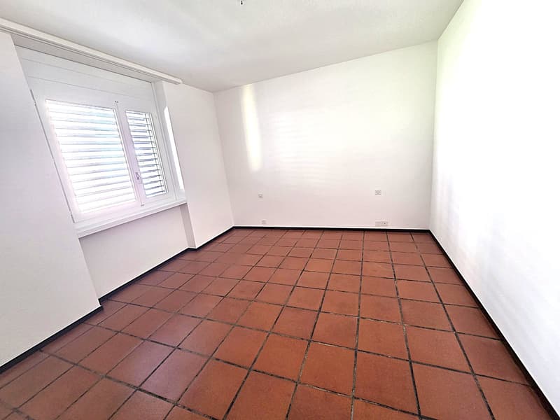 empty room, white walls, brown tiles, window with shutters