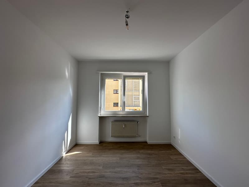 empty room, white walls, wooden floor, window, radiator