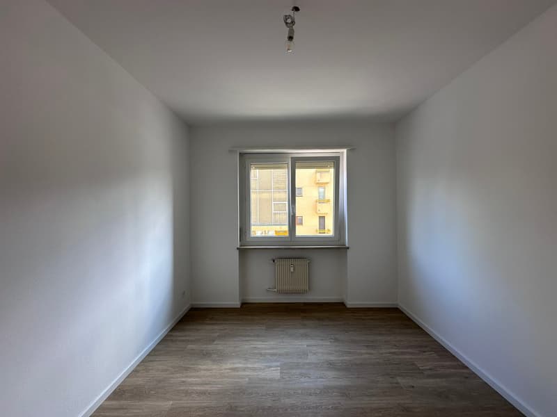 empty room, white walls, wooden floor, window, radiator