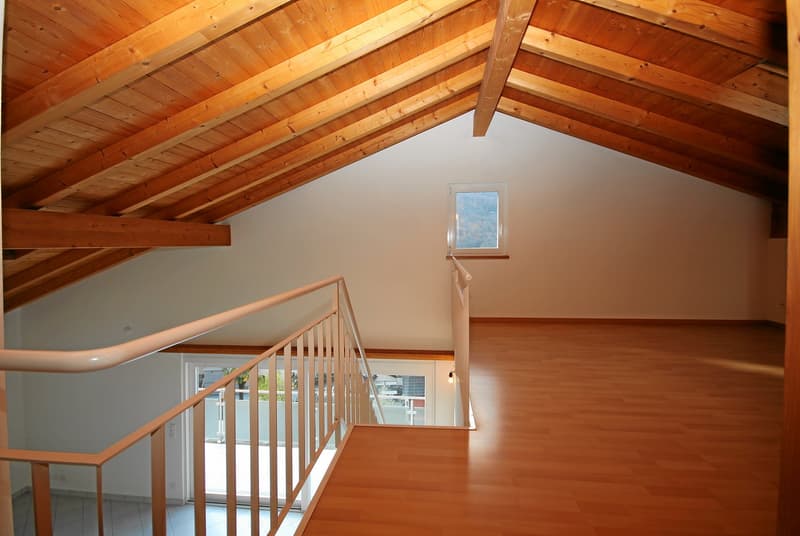 wooden beams, white walls, wooden stairs, white railing, small window