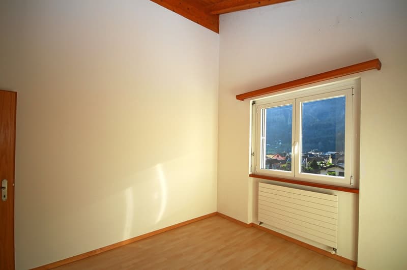 empty room with a window overlooking mountains, wooden ceiling, wooden floor