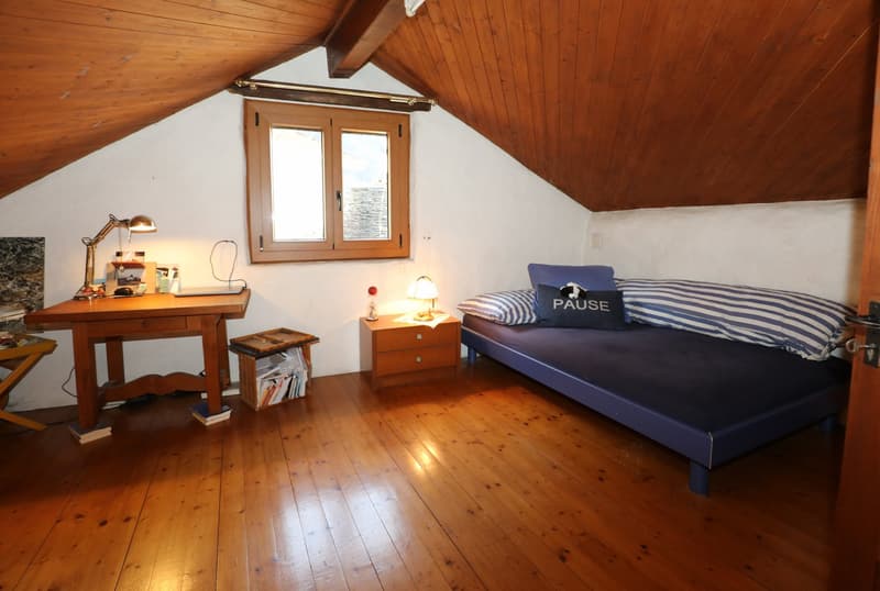 Attic bedroom with wooden ceiling, hardwood floor, desk, dresser, and a bed with striped bedding