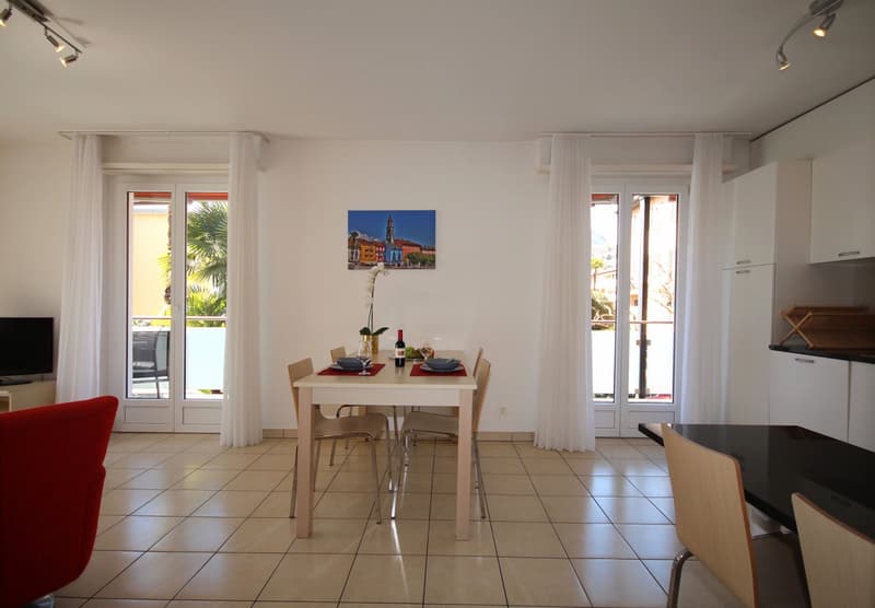 Dining room with a table, chairs, and a balcony with a view