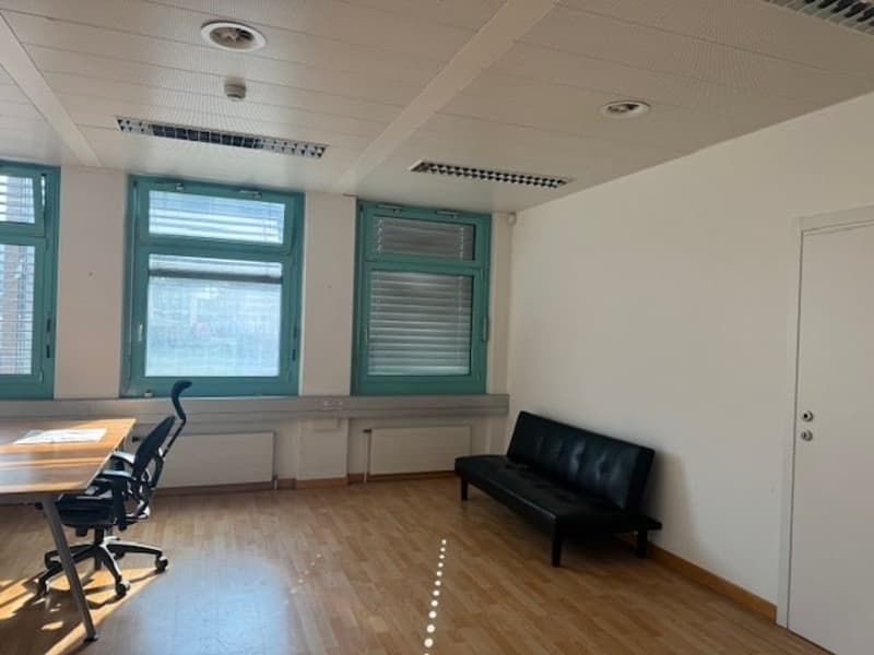 Empty room with windows, desk, chair, couch and white walls