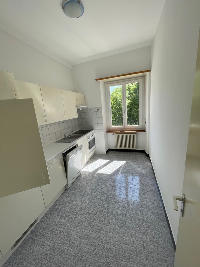 empty kitchen with tiled floor, white cabinets, gas stove, sink, dishwasher, window with view