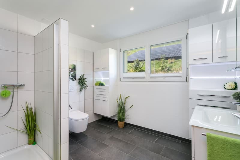 Helles, geräumiges Badezimmer mit DU-Kabine, WC, Lavabo und praktischen Einbauschränken...