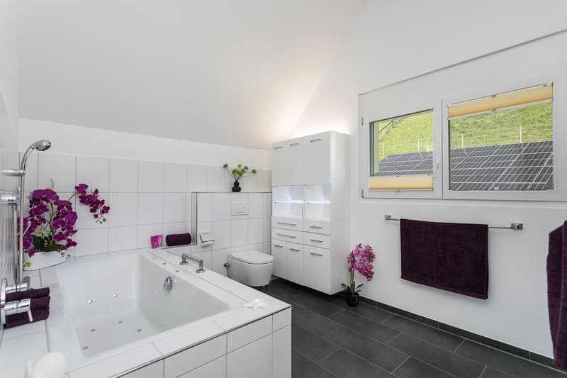 Dieses Badezimmer mit grosser Sprudelbadewanne, Edlen Einbauschränken mit Beleuchtung und ...