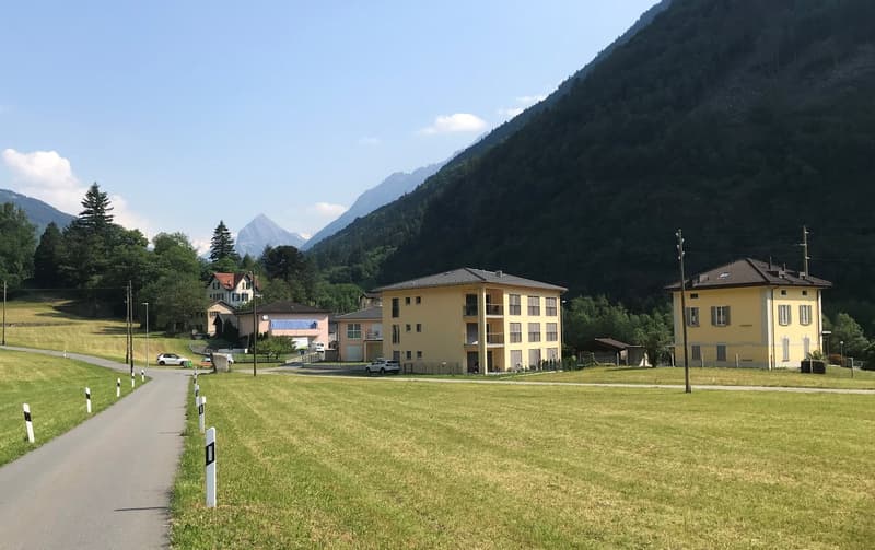 Buildings in a valley with mountains in the background