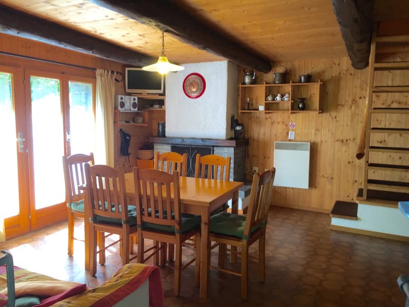 Fireplace, dining table with 6 chairs, large windows, wooden walls