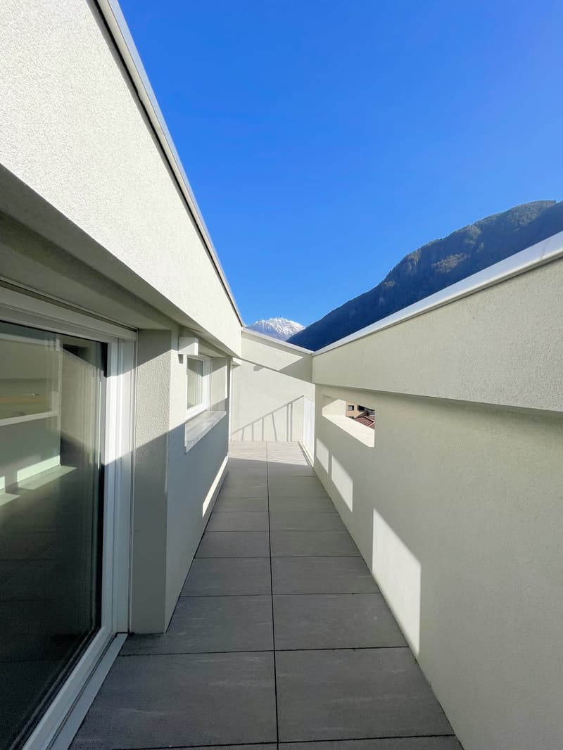 Concrete balcony with glass railings and mountain view