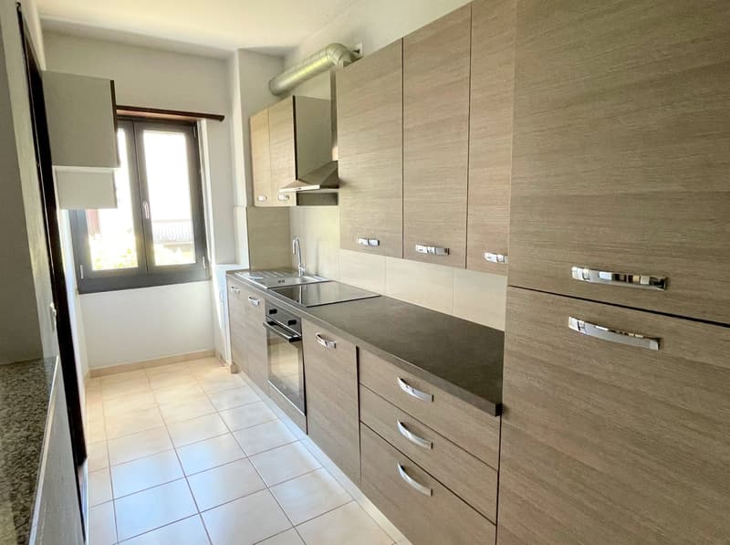 modern kitchen, tile flooring, wooden cabinets, granite countertop, stainless steel oven, sink with faucet, extractor hood