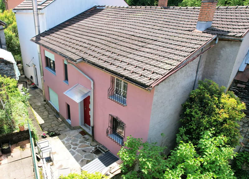 pink house, brown tiled roof, red door, garage, chimney, stone pathway, garden, terrace, trees