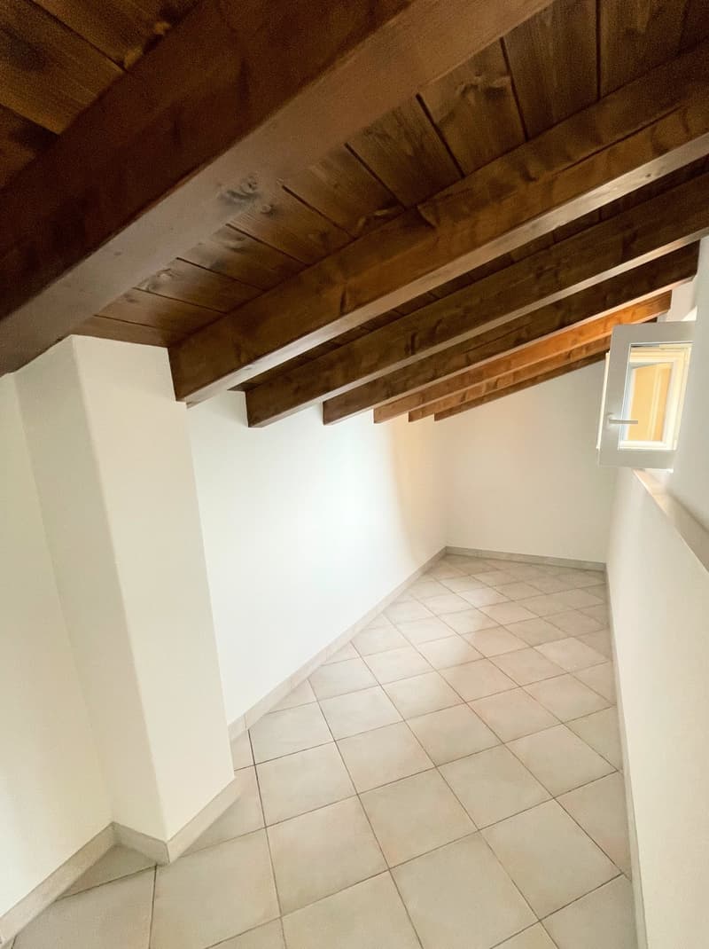 white tiled floor, wooden beams on ceiling, small window on wall