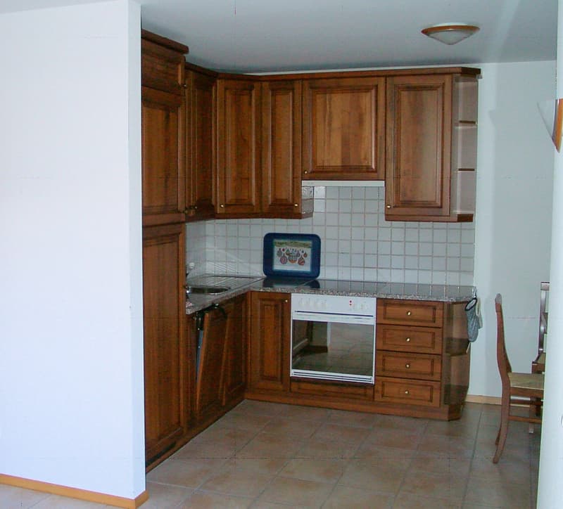 kitchen area, wooden cabinets, white tile backsplash, oven, granite countertop, tiled flooring