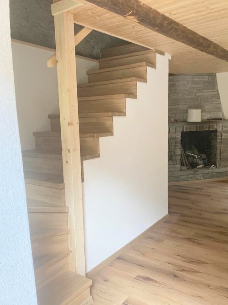wooden stairs, white walls, wooden flooring, fireplace with stone wall