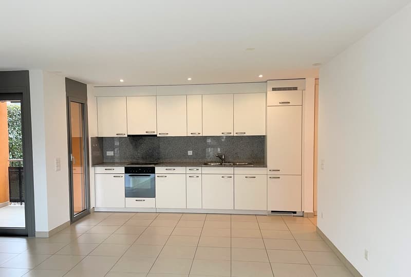 modern kitchen with integrated appliances, tiled floor, open to a balcony with railings