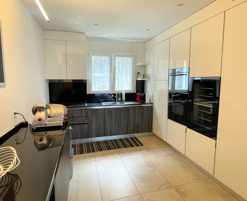 modern kitchen, white cabinets, white walls, dishwasher, washing machine, under cabinet lights, gas stove