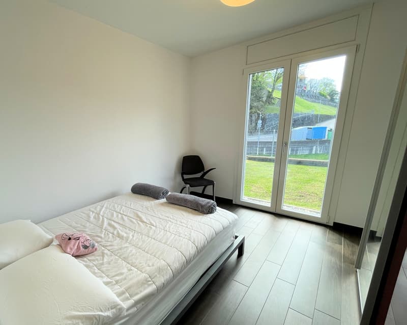bed, 2 pillows, blanket, 1 chair, large sliding glass doors