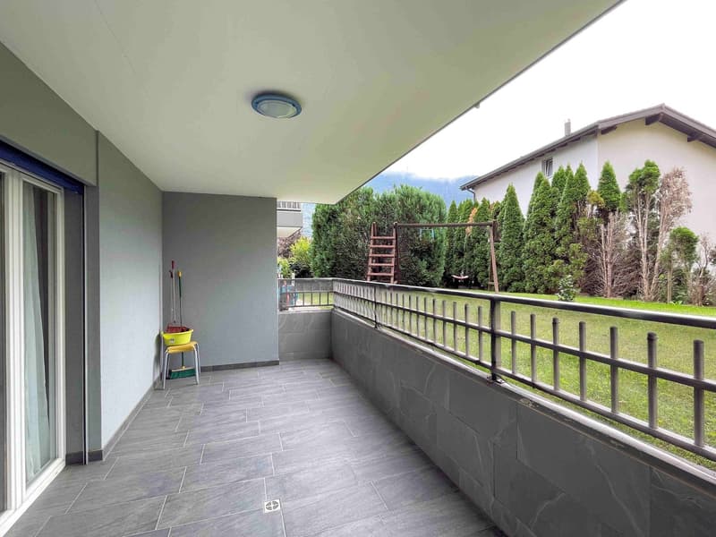Balcony with tiled flooring, railings, outdoor grass, plants, tools on chair