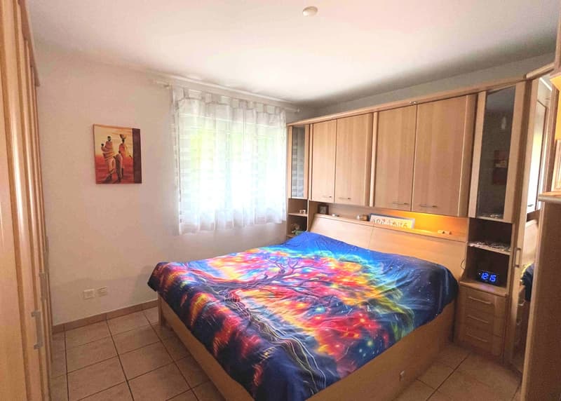 Double bed, nightstand, wooden cabinet, tiled floor, window, curtains, picture frame, alarm clock