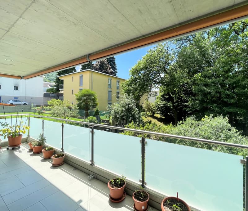 tiled floor, glass railings, view to a garden and buildings