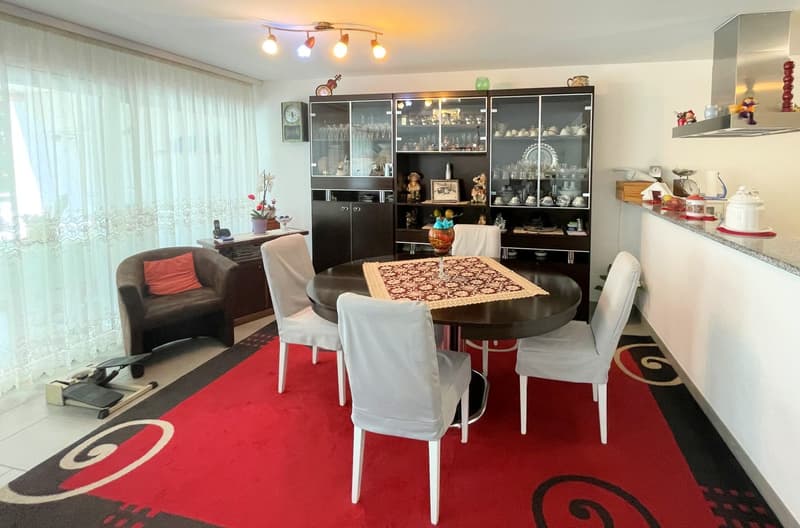 round dining table with 6 chairs, wooden cabinet, carpet, kitchen counter, armchair