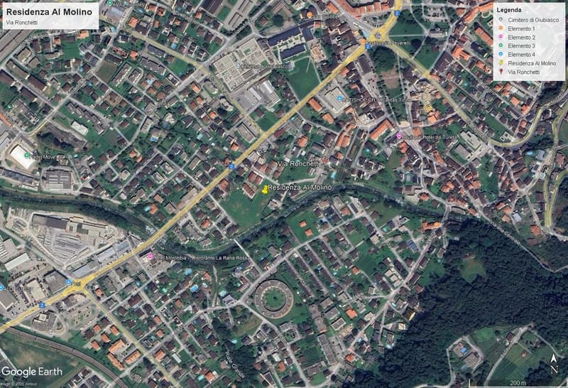 Urban area with residential buildings, roads, and green spaces, labeled landmarks and routes