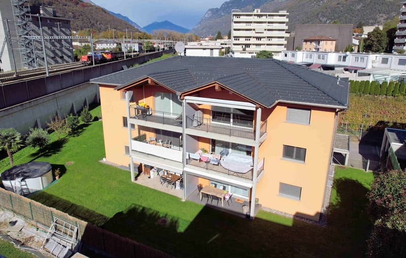 3 story house, orange exterior, multiple balconies, located in a residential area with a view of the mountains