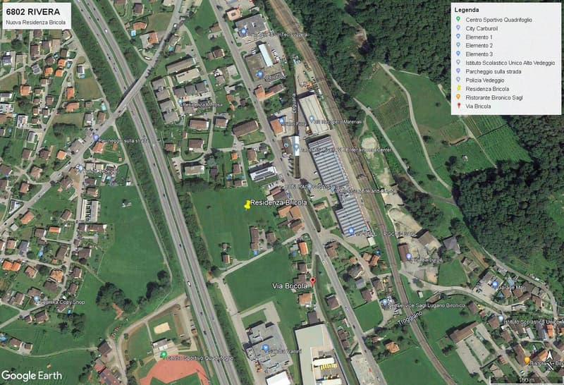 Aerial view of a town with residential buildings, a sports center, a school, a restaurant, and a police station.