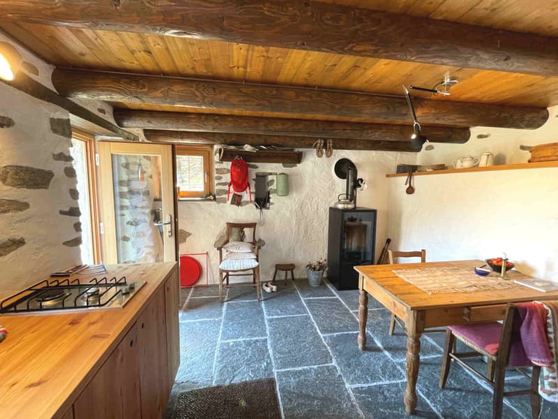 wooden beams, stone walls, fireplace, wooden table, wooden chair, gas stove, wooden cabinet