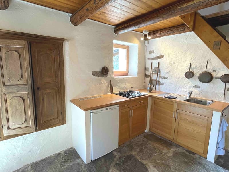 kitchen with wooden cabinets, gas stove, sink, dishwasher, wooden ceiling, stone floor