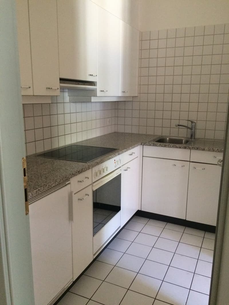 White cabinets, granite countertops, tiled backsplash, built-in dishwasher, electric stove