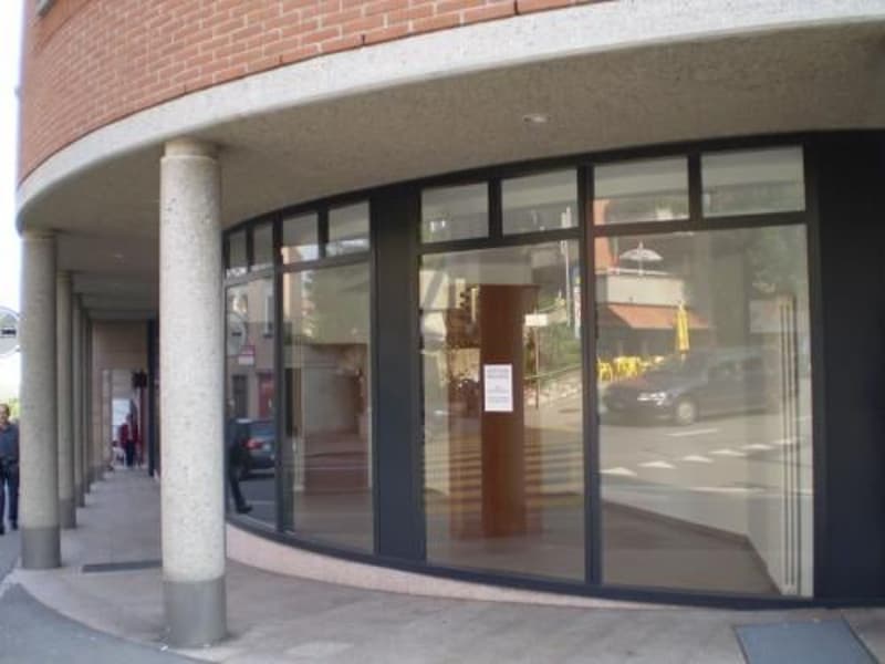 modern building, brick walls, large glass windows, metal columns, reflective glass, pedestrian area