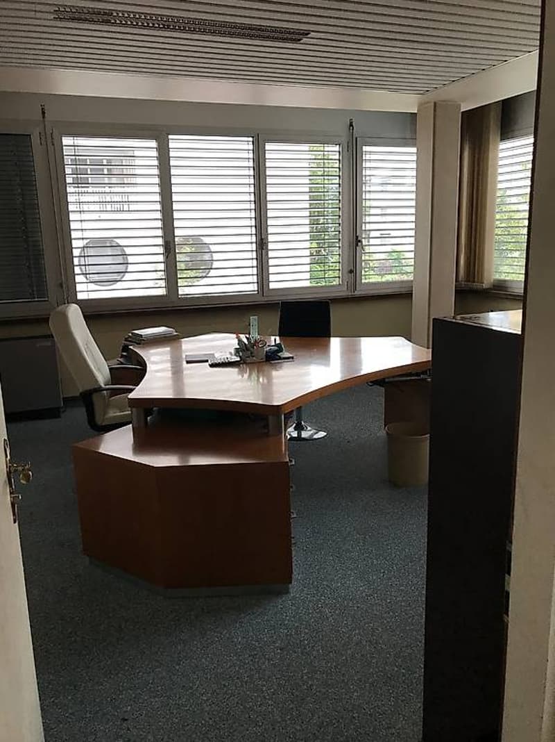 Office: large desk, two office chairs, waste bin, windows with blinds