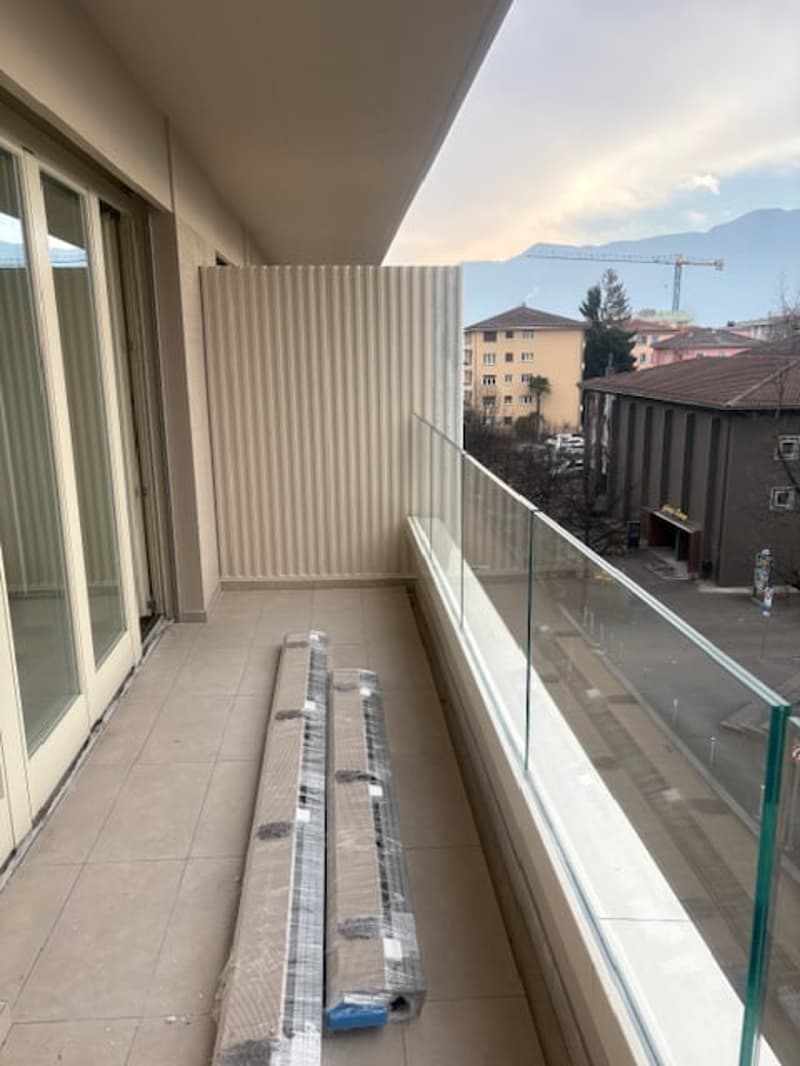 tiled floor, large windows, glass railing, city view, mountains in the background