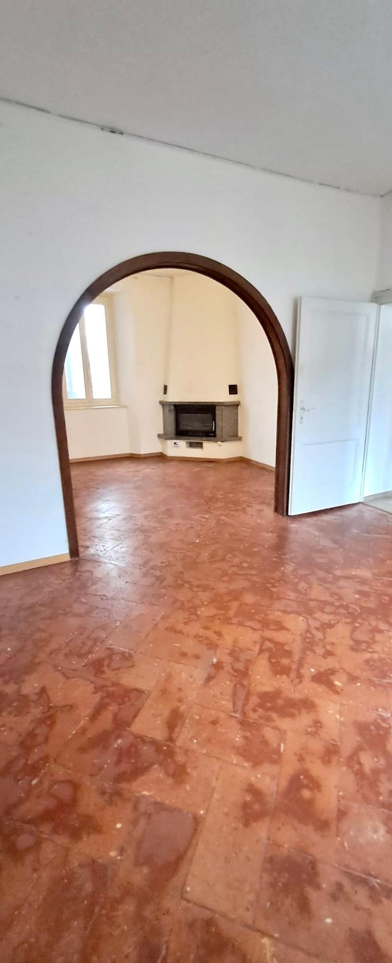 empty room, fireplace, arched doorway, hardwood floors