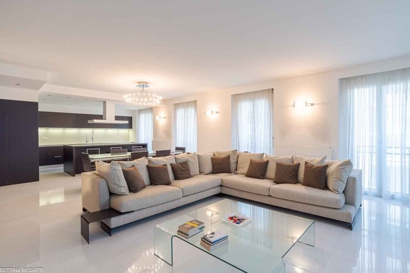 white walls, glass table, white tiles, sectional sofa, beige cushions, living area